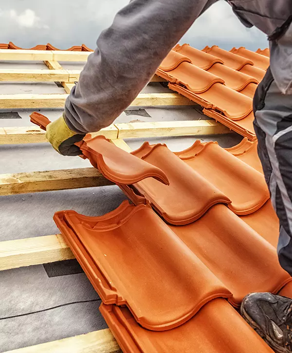 Roofer at work, installing clay roof tiles, roofing in Omaha Nebraska