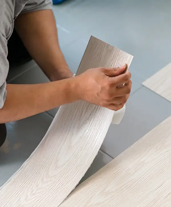 A person installing new vinyl tile floor